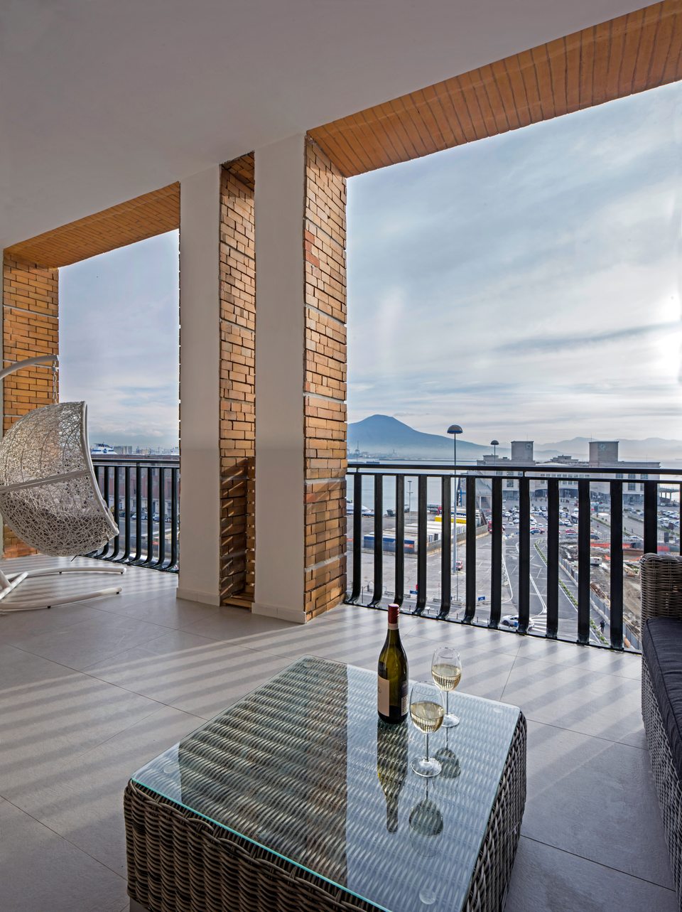Terraza privada con sillón colgante y vistas al mar y al Vesubio.