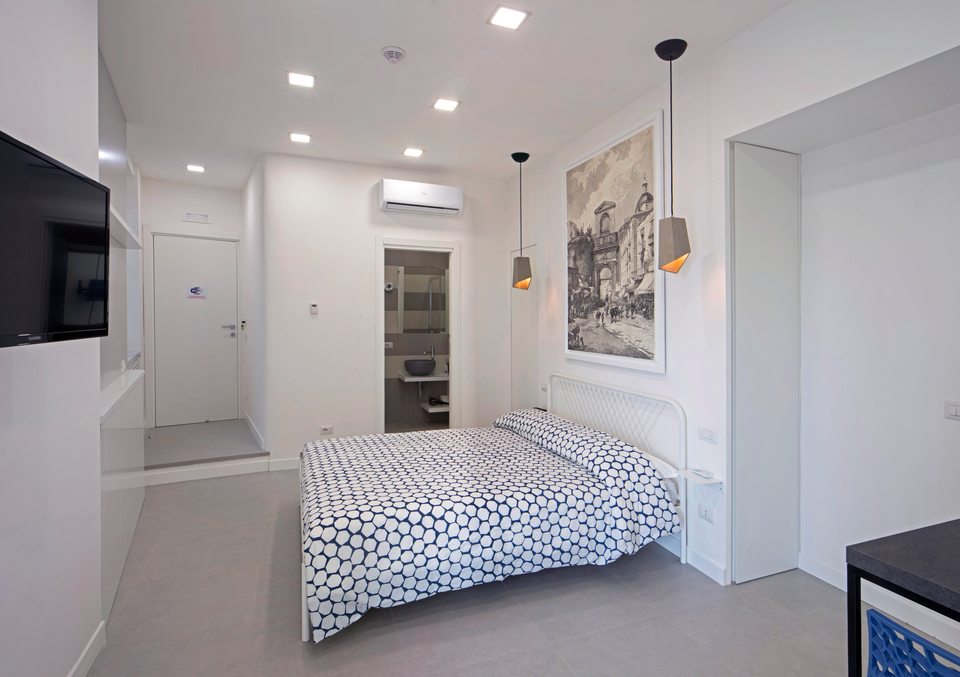 Zona de descanso con cama doble y paredes claras.