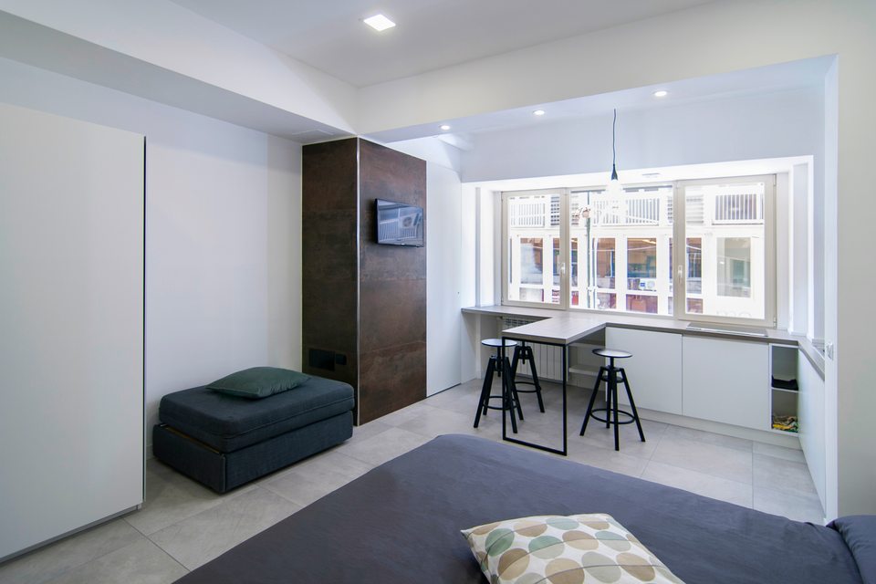Espace de vie avec une assise et une table près de la fenêtre.