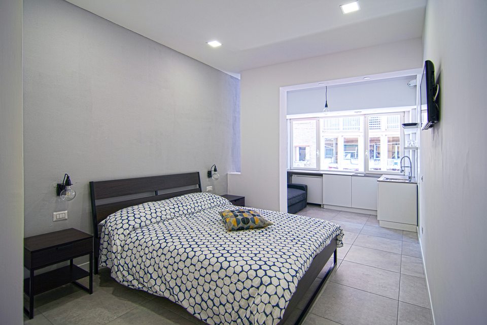 Letto matrimoniale e finestra con affaccio sulla città.