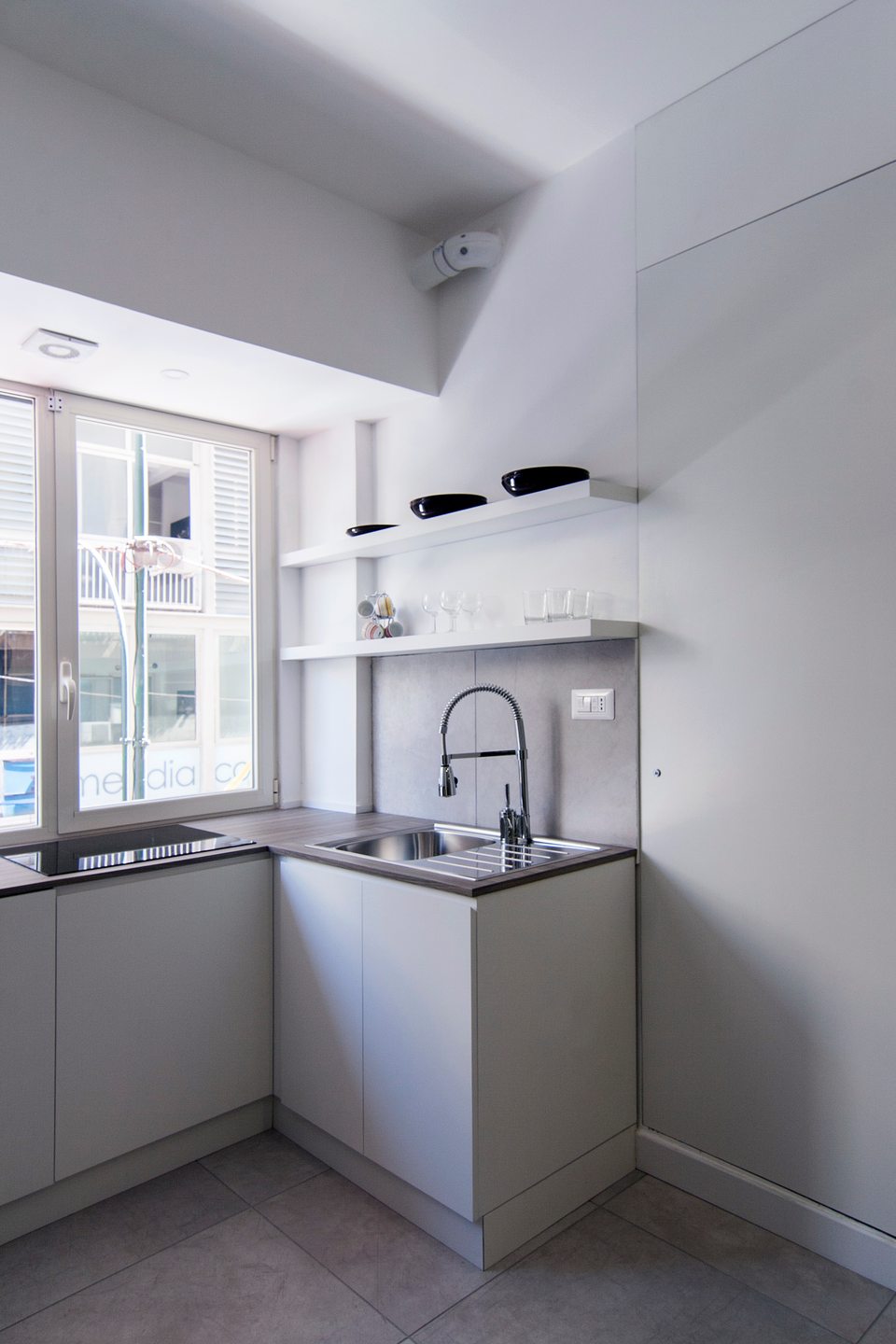 Kitchenette with a sink and hob beside the window.
