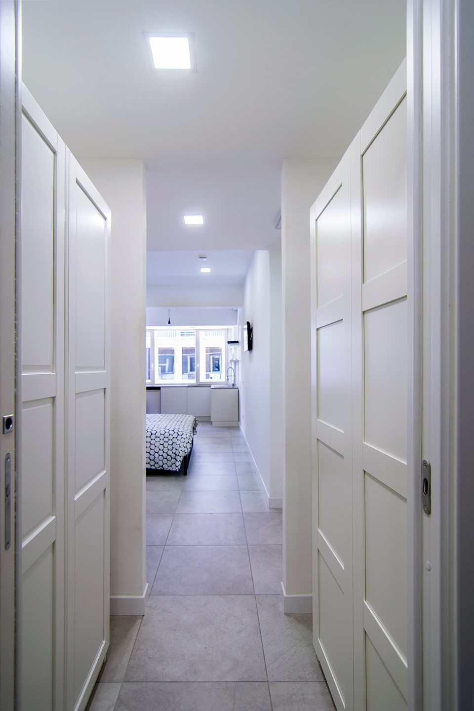 Studio entrance with a wardrobe and a view towards the sleeping area.